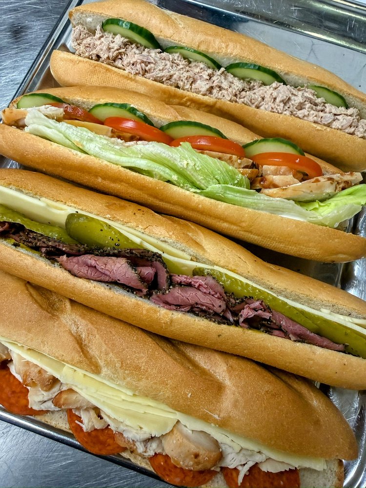 A tray of filled baguettes &mdash; tuna and cucumber, chicken salad, pastrami and cheese